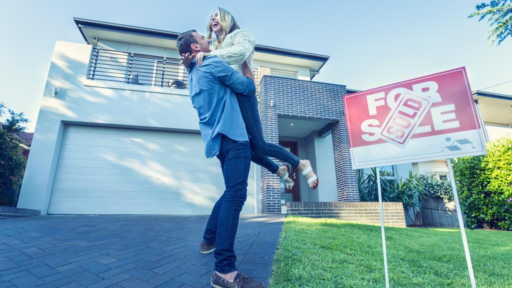 Couple standing in front of a new home.