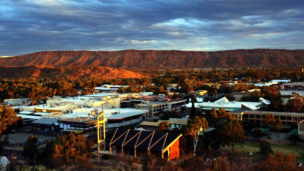 Generic photo of the sun setting over the town of Alice Springs with the MacDonnell Ranges in the background in the Northern Territory.