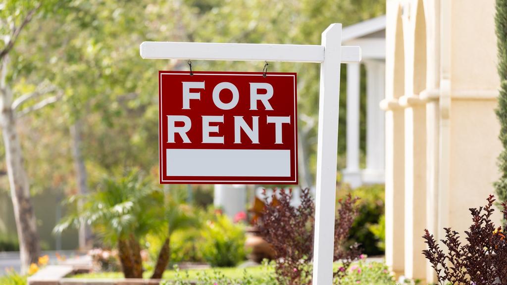 Red For Rent Real Estate Sign in Front House