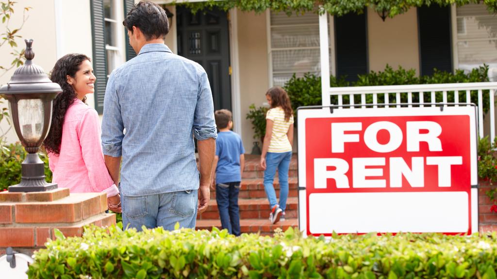 Smiling Hispanic family outside rental home