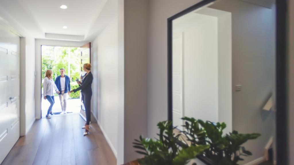 Real estate agent showing a young couple a new house.