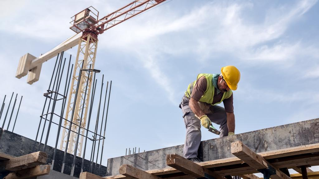 Worker At Construction Site Is Fixing The Form For The Beam