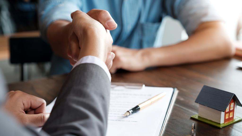 Estate agent shaking hands with his customer after contract signature