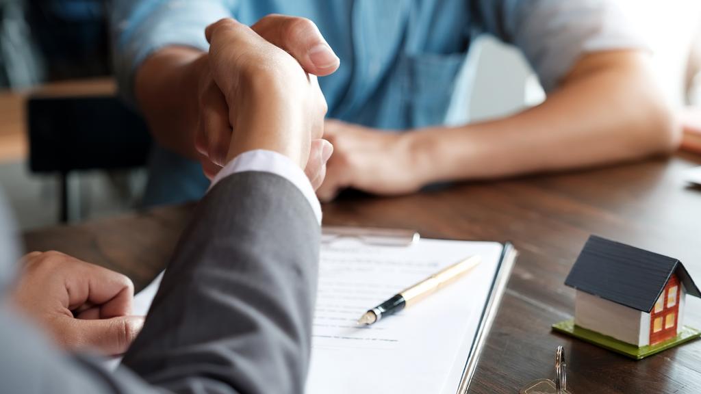 Estate agent shaking hands with his customer after contract signature