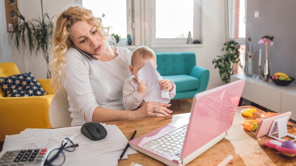 Mother talking on smart phone at home office