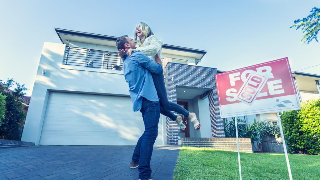 Couple standing in front of a new home.