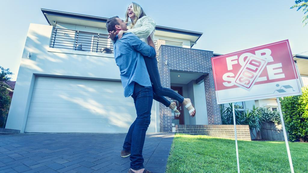 Couple standing in front of a new home.