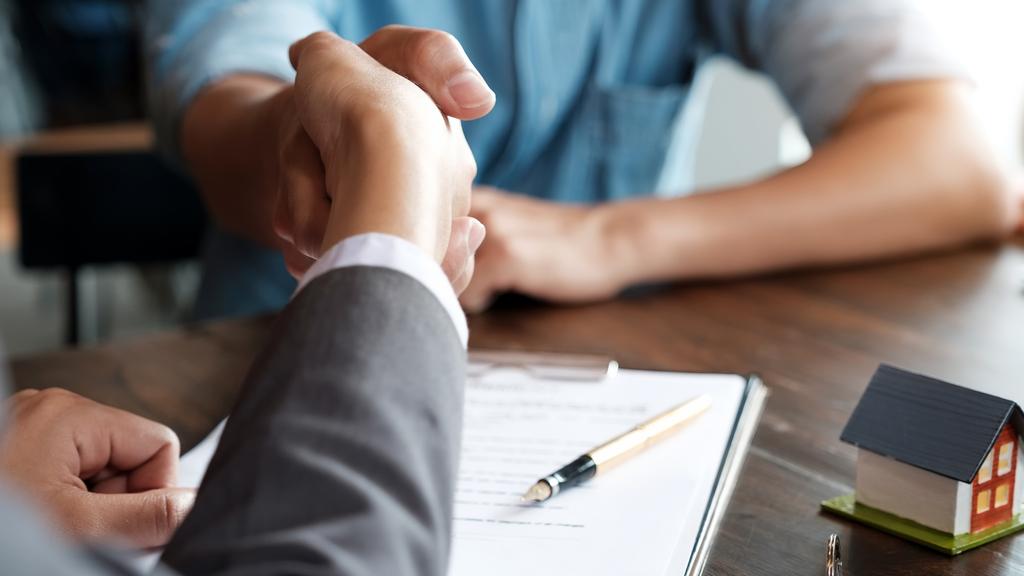 Estate agent shaking hands with his customer after contract signature