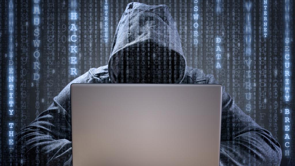 Computer hacker stealing data from a laptop