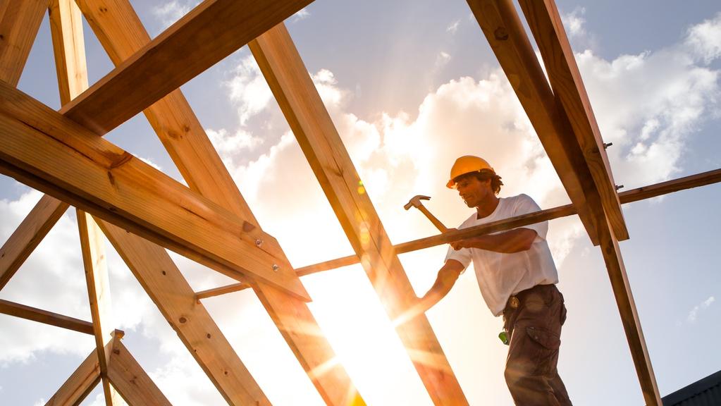 roofer worker builder working on roof structure at construction site